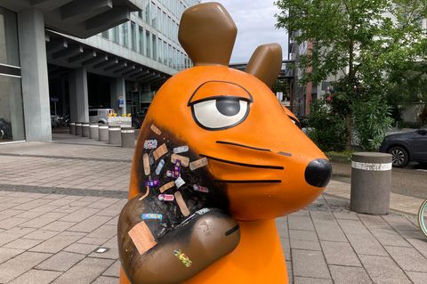 Pflaster kleben auf dem verbrannten Hald der Maus-Figur vor dem WDR in Köln