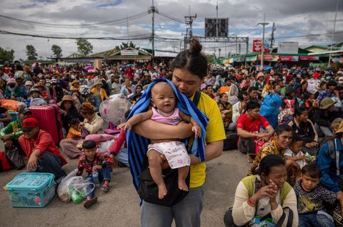 Eine Frau wartet mit ihrem Baby an einem Grenzübergang, nachdem Thailand und Kambodscha einen Waffenstillstand vereinbart haben