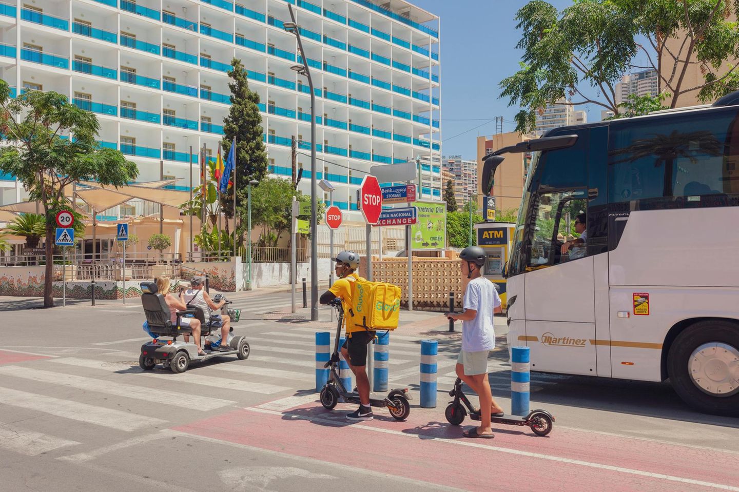 Straßenkreuzung, zwei Urlauber fahren auf einem Vierradscooter