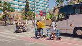 Straßenkreuzung, zwei Urlauber fahren auf einem Vierradscooter