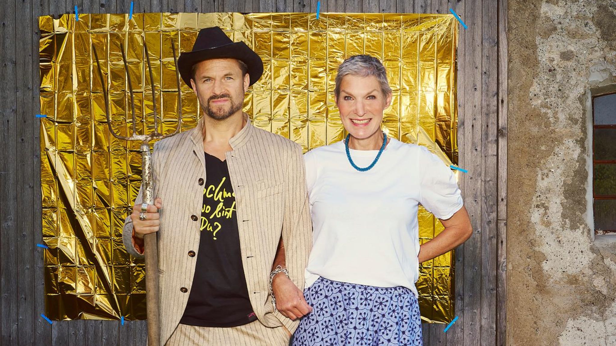 Philipp Hochmair und Von der Leyen posieren vor einem goldenen Hintergrund