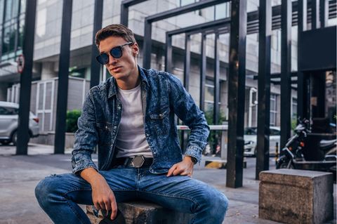 Deal-News: Ein Mann sitzt mit seiner G-Star-Jeans auf einer Mauer.
