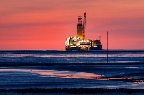 Vor leuchtend rotem Abendhimmel gibt die Ölplattform Mittelplate in der Nordsee ein romantisches Bild ab