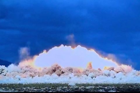 Eine riesige, feurige Explosion tut sich vor dunklem Himmel auf.