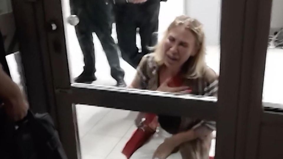 Die Gästin kniet vor einem geschlossenem Gate