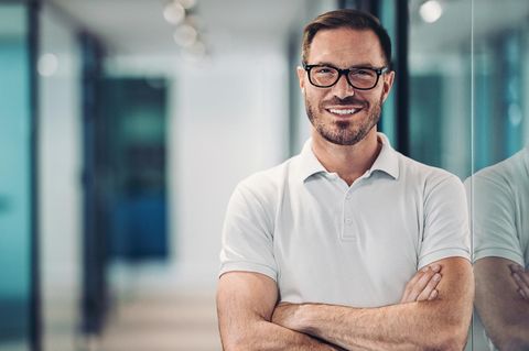 Lächelnder mittlerer Erwachsener im Poloshirt