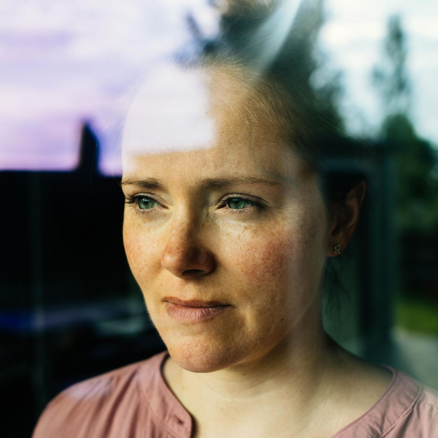 Eine Frau hatte eine Affäre und schaut nachdenklich aus dem Fenster