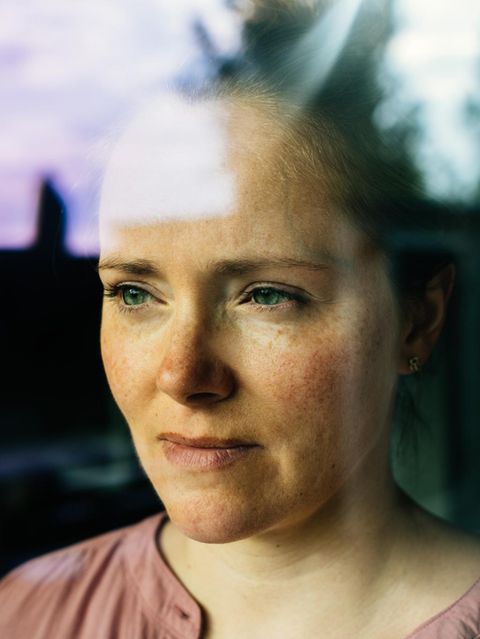 Eine Frau hatte eine Affäre und schaut nachdenklich aus dem Fenster