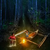 Junge in Boot zeigt erwachsenem Mann was er gefangen hat