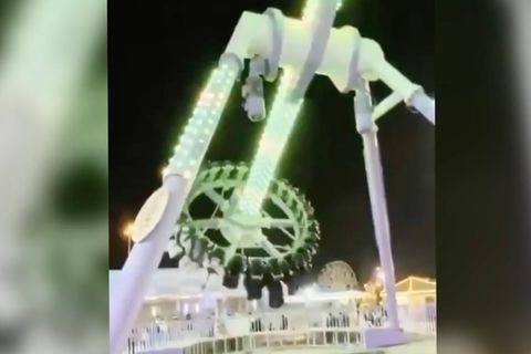 Ein bunt beleuchtetes Fahrgeschäft in Saudi-Arabien mitten in der Fahrt.