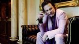 Bryan Adams – die Ausstellung: Mickey Rourke sitzt einem rosafarbenen Anzug auf einer Chaiselounge