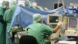 Anästhesist neben einem Patientenmonitor während einer Operation