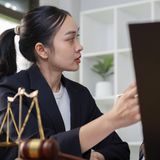 Eine Frau in einem Gespräch mit Rechtswaage im Vordergrund