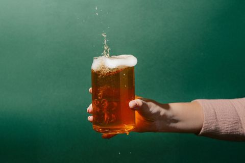 eine Hand hält ein Glas Bier
