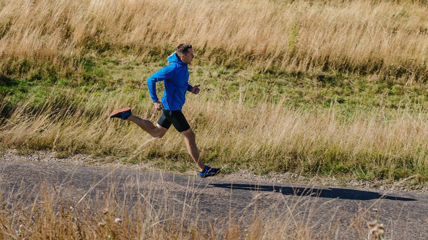 Gravel Running: Läufer auf einem Feldweg mit Laufjacke