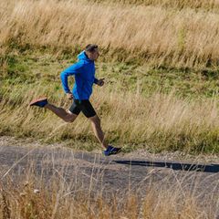 Gravel Running: Läufer auf einem Feldweg mit Laufjacke