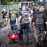 festivalbesucher auf dem Weg zum Gelände - durch den Schlamm