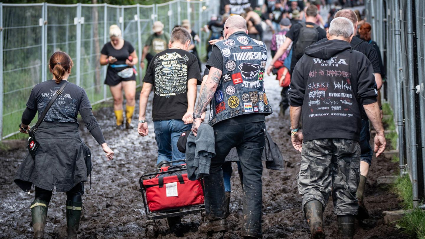 festivalbesucher auf dem Weg zum Gelände - durch den Schlamm