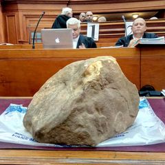 Ein großer Stein liegt auf einem Tisch vor Gericht