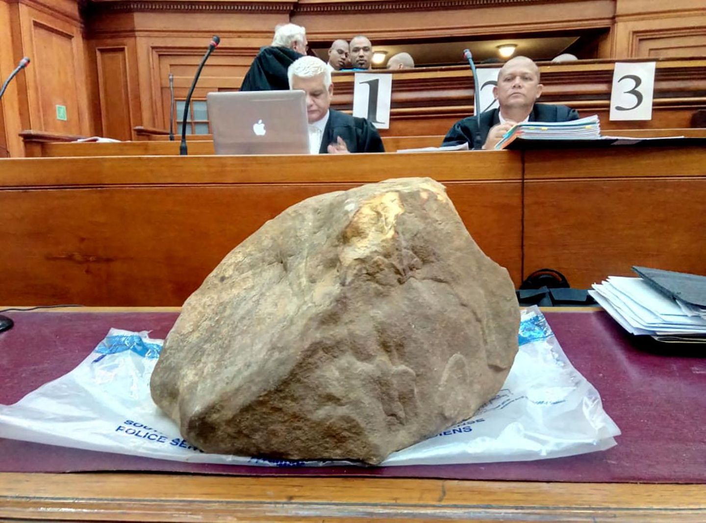 Ein großer Stein liegt auf einem Tisch vor Gericht