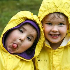 Kleine Kinder in gelben Regenmänteln
