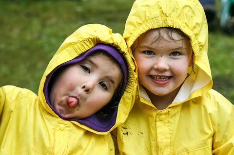 Kleine Kinder in gelben Regenmänteln
