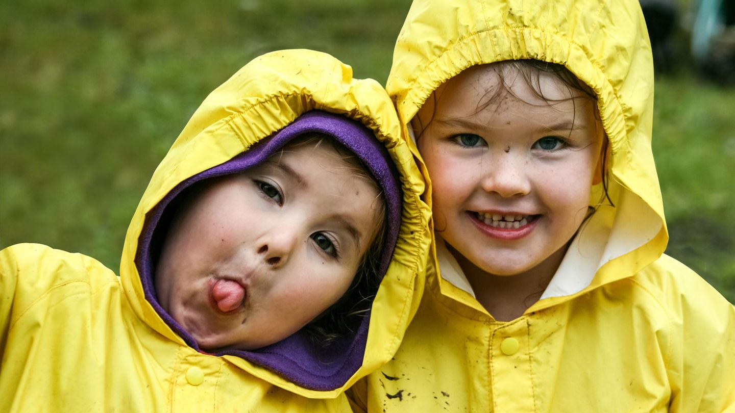 Kleine Kinder in gelben Regenmänteln