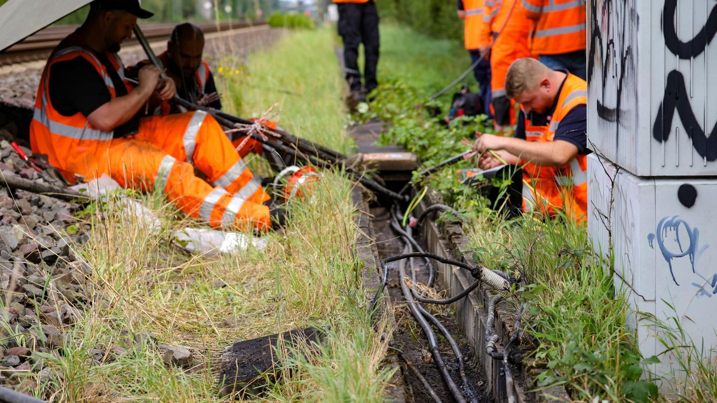 Mitarbeiter der Deutschen Bahn reparieren Kabel an der Stelle, wo der zweite Brandanschlag festgestellt wurde