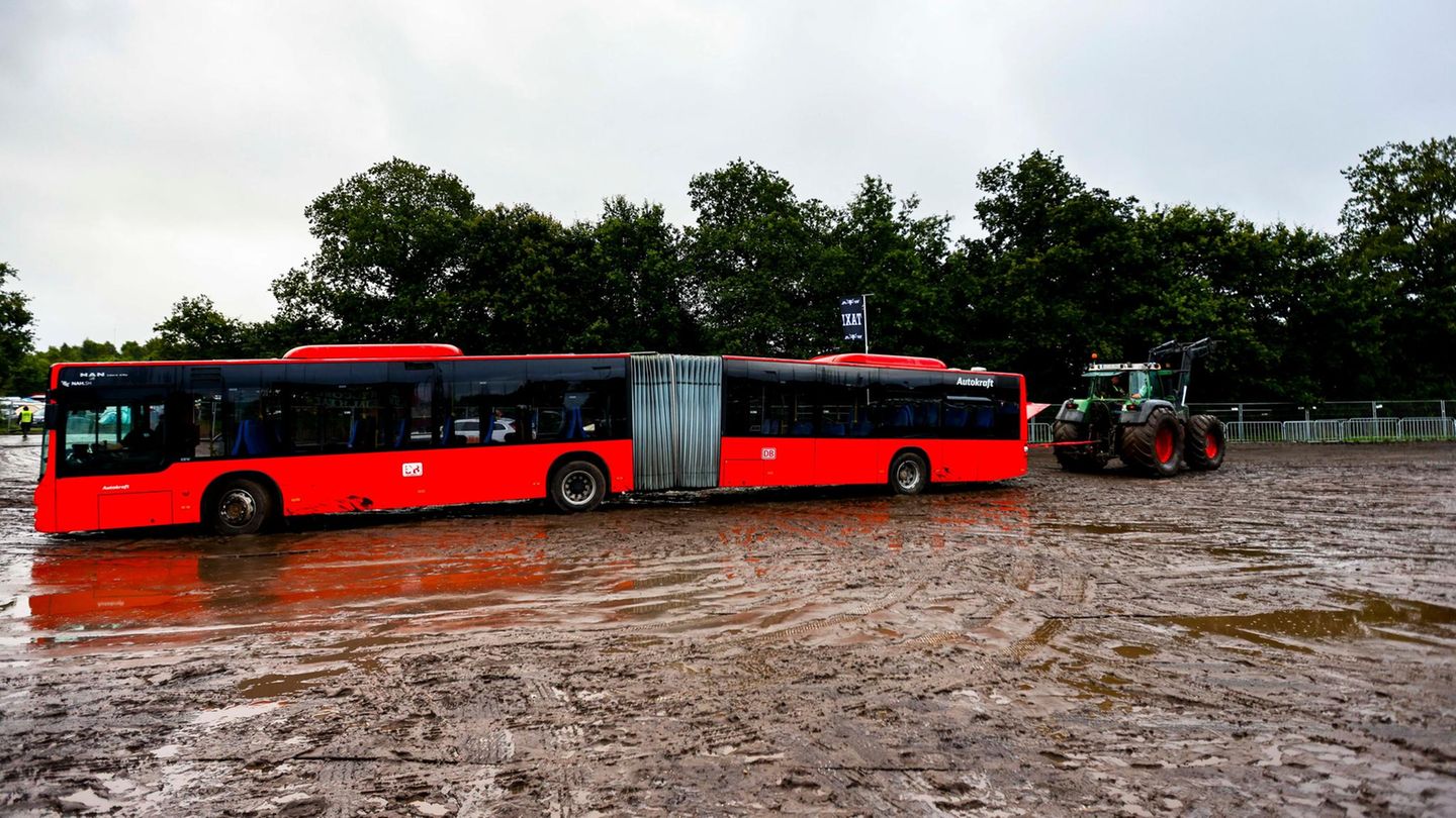 Ein Bus steckt im Matsch fest, dahinter ist ein Traktor zu sehen