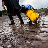 Ein Mann zieht sein Gepäck durch den Matsch