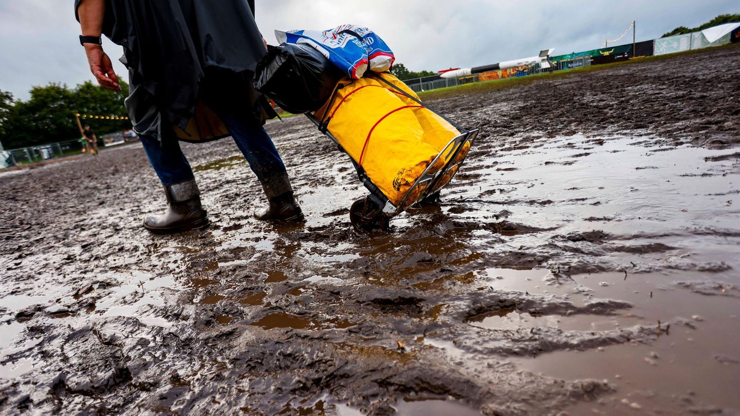Ein Mann zieht sein Gepäck durch den Matsch