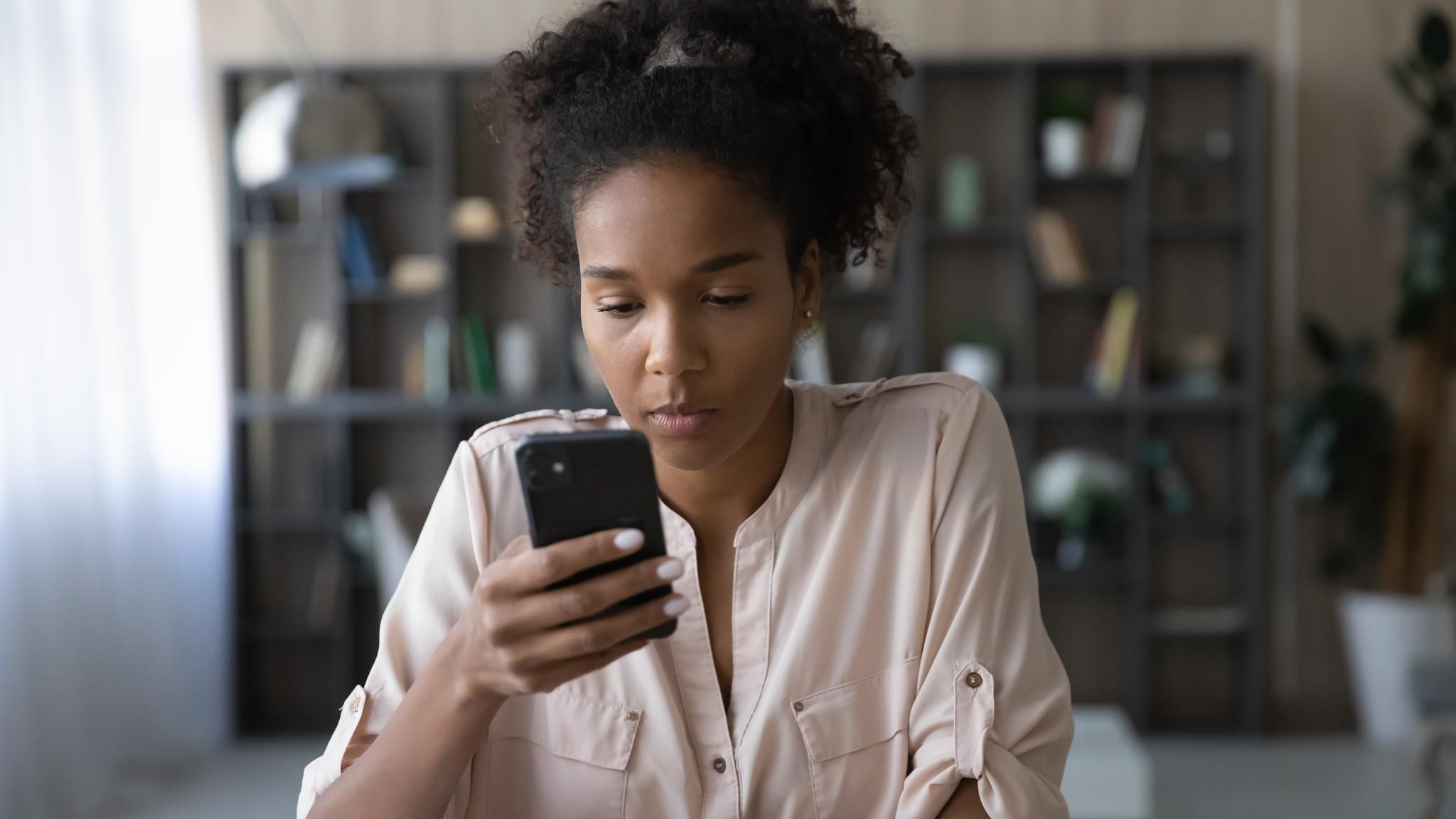 Junge Generation Z Frau sitzt vor Handy