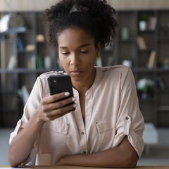 Junge Generation Z Frau sitzt vor Handy