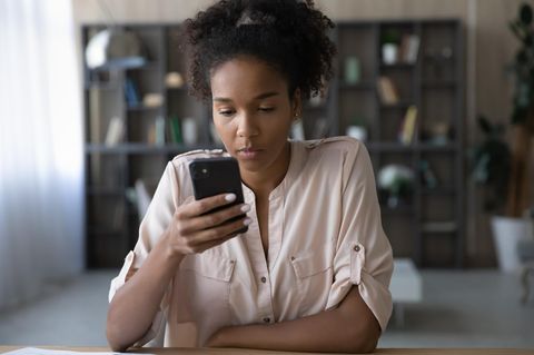 Junge Generation Z Frau sitzt vor Handy
