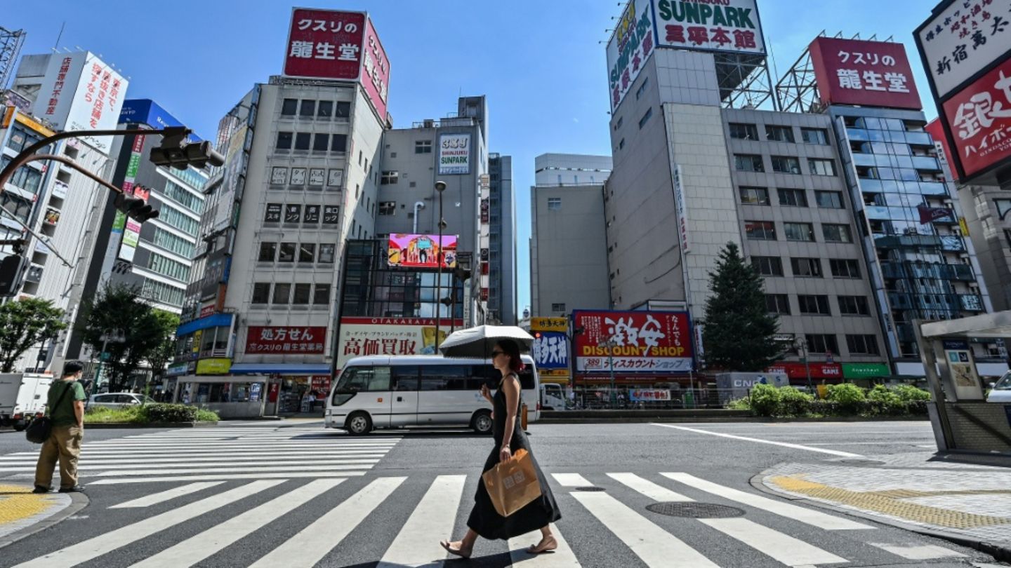 Frau schützt sich in Tokio vor der Sonne