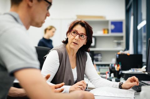Frau und Mann unterhalten sich im Büro