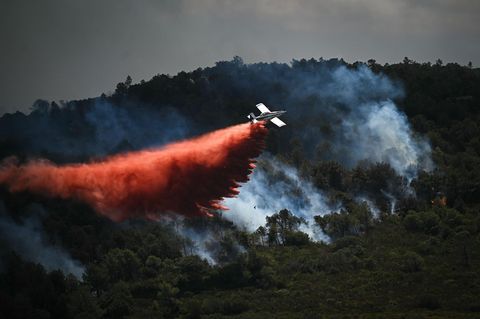 Ein Löschflugzeug wirft in Südfrankreich Löschmittel über einem Waldbrand ab