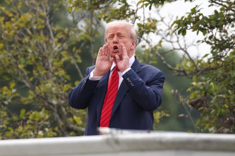 Donald Trump steht auf einem Dach und ruft
