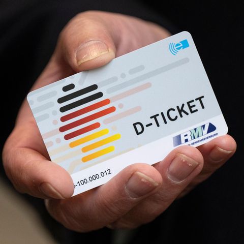 Eine Hand hält ein Deutschlandticket