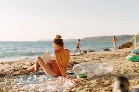 Erholung im Urlaub: Eine Frau liest ein Buch am Strand