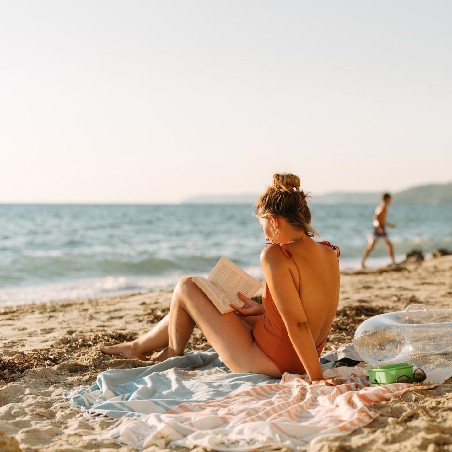 Erholung im Urlaub: Eine Frau liest ein Buch am Strand