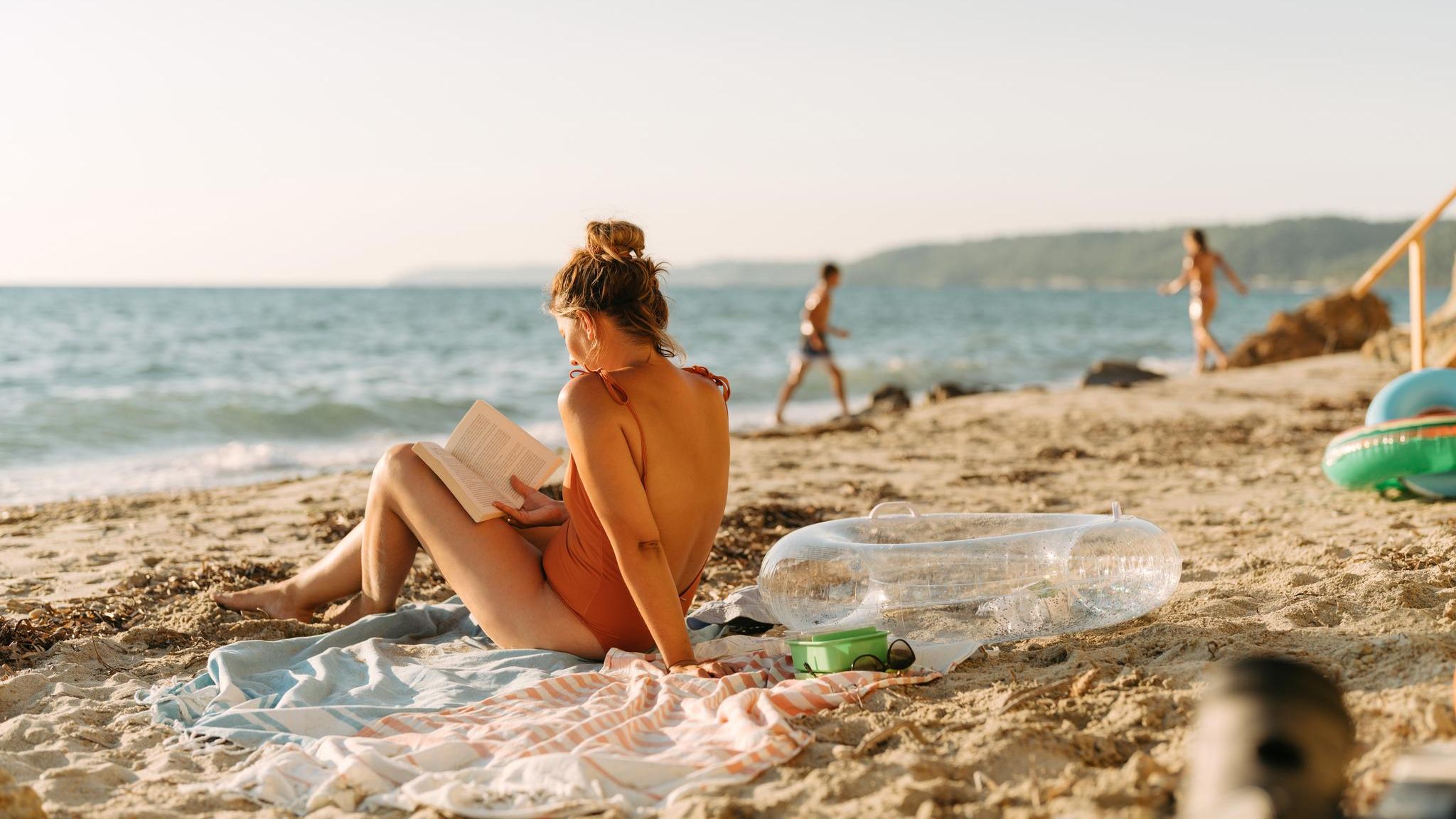 Erholung im Urlaub: Eine Frau liest ein Buch am Strand