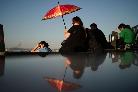 Eine Frau schützt sich an einem heißen Julitag in Istanbul vor der Sonne