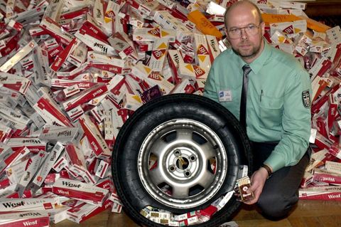 In einem aufgeschnittenen Autoreifen sind Stagen mit Zigaretten versteckt