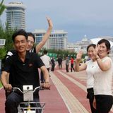 An der Strandpromenade winken Einheimische dem Fotografen zu