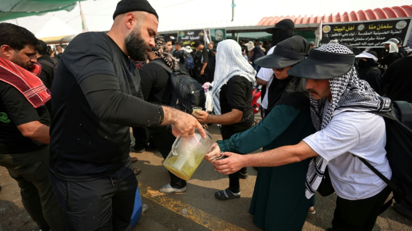 Freiwillige verteilen Wasser an Pilger im Irak