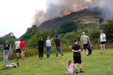 Menschen beobachten ein Feuer auf dem Arthur's Seat im Holyrood Park in Edinburgh
