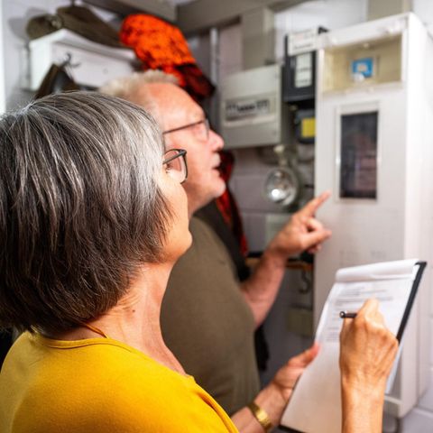 Ein älteres Pärchen steht vor einem Stromzaehler