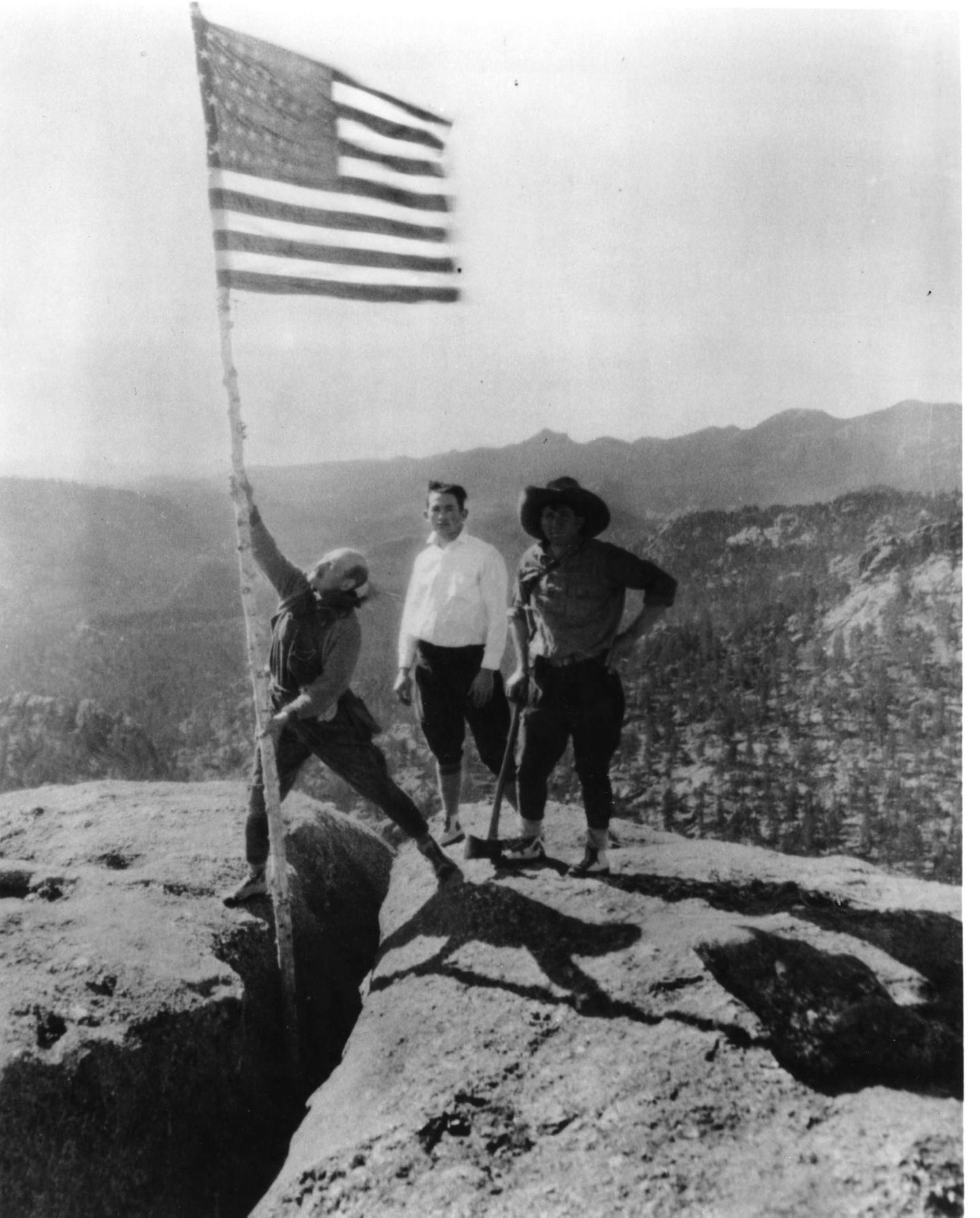 Menschen hissen die US-Flagge auf Mount Rushmore