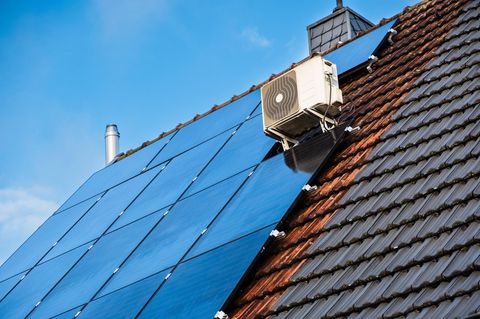 Klimaanlage auf einem schrägen Solardach vor blauem Himmel